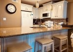 Recently remodeled kitchen with granite counter-top bar and comfortable barstools.